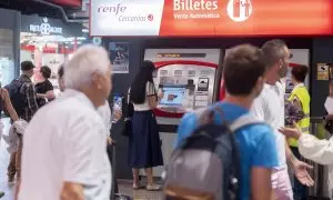 Varias personas adquieren sus billetes en las taquillas de venta automática de la estación de tren de Atocha.