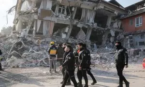 Oficiales de Policía turcos caminan frente a un edificio dañado después del terremoto mortal en Hatay, Turquía, 11 de febrero de 2023