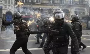Fuegos artificiales impactan contra los cuerpos de seguridad franceses en las manifestaciones contra la reforma de las pensiones en París, a 23 de marzo de 2023.