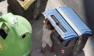 Fotografía de archivo de un hombre buscando en un contenedor de basura.