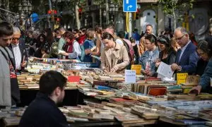 Gent passejant i mirant llibres per les parades de la superilla literària per Sant Jordi a Barcelona.
