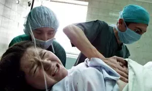 Imagen de archivo de una mujer de parto auxiliada por dos enfermeras en la maternidad de Quito, a 27 de junio de 2003.