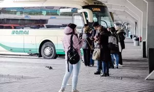 Varias personas sin mascarilla esperan para subir a un autocar en la Estación Sur de Autobuses Méndez Álvaro, en Madrid.