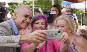 Antonio Muñoz, candidato del PSOE en Sevilla, se hace una foto con dos simpatizantes durante un acto de campaña.