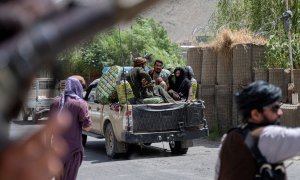 En esta fotografía tomada el 8 de julio de 2022, los combatientes talibanes pasan por un puesto de control de carretera cerca en la provincia de Panjshir, en Afganistán.