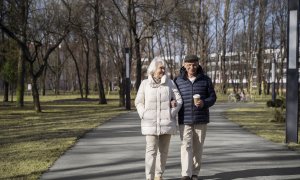 Vista de dos personas mayores caminando en un parque (archivo)