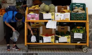 Una mujer compra unas berenjenas en una frutería en la localidad malagueña de Ronda. REUTERS/Jon Nazca