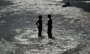 Dos personas se refrescan en la playa de Sitges en una imagen de archivo.