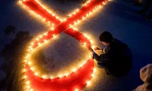 Una persona enciende velas formando una cinta roja por el día Mundial del SIDA, en una imagen de archivo del 30 de noviembre de 2020.