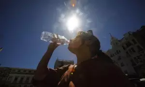 31/07/2023.-Una mujer se refresca bebiendo agua en el centro de Córdoba donde se ha dado aviso naranja por altas temperaturas.