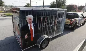 Un seguidor del expresidente estadounidense Donald Trump con un remolque que muestra imágenes de líderes demócratas en una celda, a las puertas de la cárcel del condado de Fulton, en Atlanta, Georgia, este 24 de agosto de 2023.