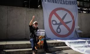 Un manifestante sostiene un cartel que dice 'Roban salud' en la 98ª Marea Blanca por la Sanidad Pública, en la plaza de Juan Goytisolo, a 19 de marzo de 2023, en Madrid, (España).