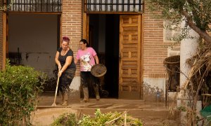 Las vecinas ayudan a sacar agua del Ayuntamiento de Yunclillos, uno de los edificios más perjudicados por la DANA.