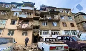 Una vista muestra un edificio residencial y automóviles dañados tras el lanzamiento de una operación militar por parte de las fuerzas armadas de Azerbaiyán en la ciudad de Stepanakert en Nagorno-Karabaj, una región habitada por personas de etnia armenia,
