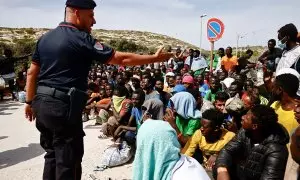 Un policía italiano habla a los migrantes que han llegado a la isla siciliana de Lampedusa, a 18 de septiembre de 2023