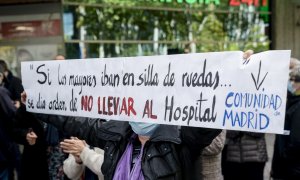 Una mujer sostiene una pancarta donde se lee "Si los mayores iban en silla de ruedas... se dio la orden de no llevar al hospital", durante una concentración frente a la Asamblea de Madrid, a 4 de noviembre de 2021, en Madrid (España).