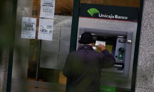 Un hombre saca dinero de Unicaja Banco tras anunciar un beneficio de 285 millones hasta septiembre, un 4,9% más, a 30 de octubre de 2023, en Madrid. Fernando Sánchez / Europa Press