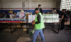 Varios voluntarios atienden a las personas que llegan a buscar comida en el almacén del Banco de Alimentos de Lugo, Galcia, a 2 de mayo de 2023. Carlos Castro / Europa Press