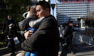 Un hombre con su hijo a las puertas de un hospital en Pekín, China, este 24 de noviembre de 2023.