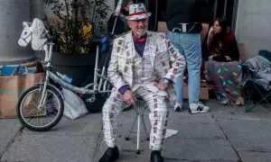 Un hombre vestido con décimos de lotería un día antes del Sorteo Extraordinario de la Lotería de Navidad, en el Teatro Real, a 21 de diciembre de 2023.