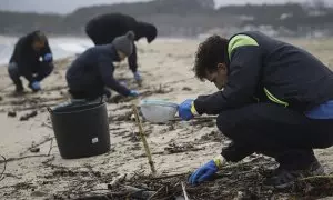 Voluntarios limpian pellets en la playa de Samil, a 10 de enero de 2024, en Vigo, Pontevedra, Galicia.