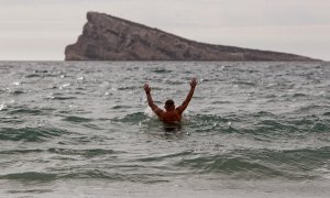 Un hombre se baña en la playa de Levante de Benidorm, en Alacant,  donde las temperaturas llegaron a superar los 25 grados a 18 de enero de 2024.