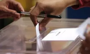 Un votante introduce su papeleta en una urna.
