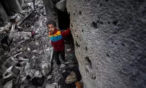 8/3(24 - Un niño palestino se encuentra entre los escombros de una casa destruida tras un ataque aéreo israelí, en Deir Al Balah, al sur de la Franja de Gaza, el 8 de marzo de 2024