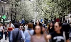 Varias personas pasean junto a árboles en flor durante el primer día de primavera, a 20 de marzo de 2024, en Madrid.