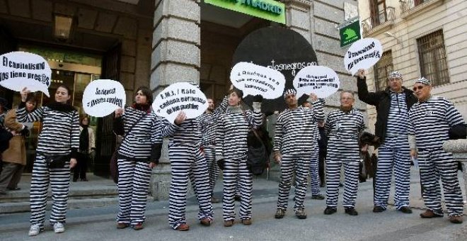 12 Personas vestidas de presos protestan por la llegada de Rato a Caja Madrid