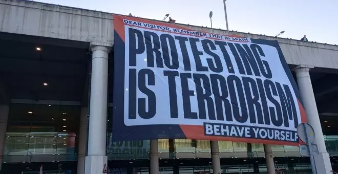 Òmnium desplega una pancarta gegant a l'aeroport del Prat: "A Espanya, protestar és terrorisme"