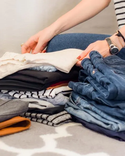 Mujer doblando ropa. Mercado de segunda mano