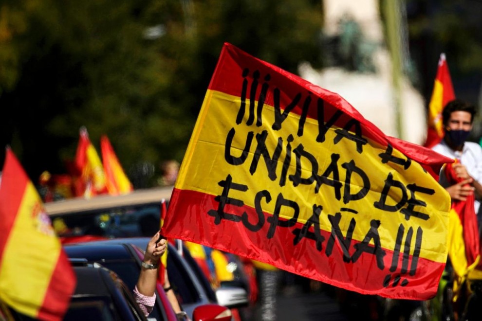 Un manifestante ondea una bandera española desde un vehículo que dice 'Viva la unidad de España' mientras la gente protesta contra el estado de emergencia organizado por el partido de extrema derecha Vox en el día nacional de España en Madrid. /Reuters