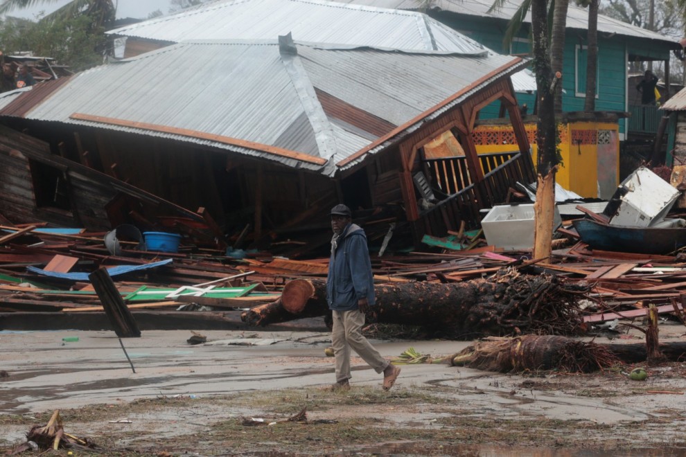 Un hombre pasa frente a una casa dañada por el paso del huracán Iota, en Puerto Cabezas