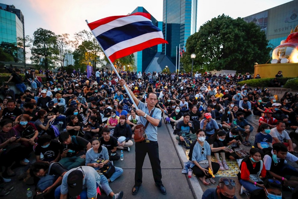 Un manifestante antigubernamental ondea una gran bandera nacional tailandesa durante una protesta que pide la reforma de la monarquía.