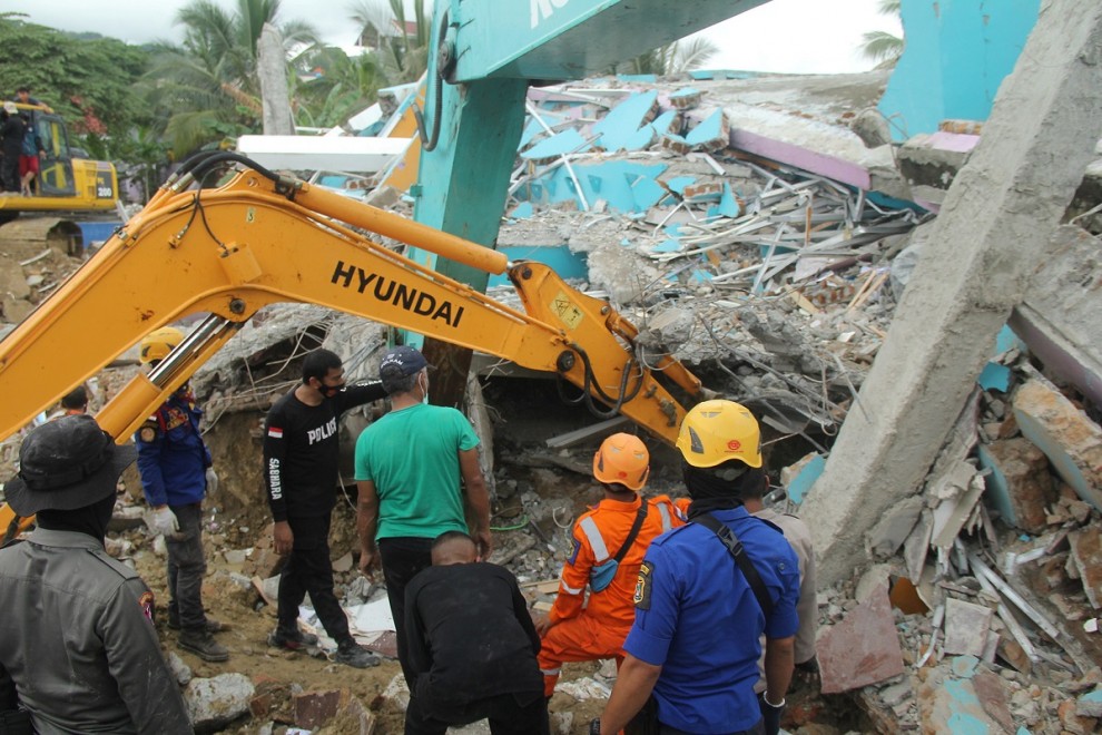 Una excavadora levanta los escombros de un hospital derruido por el terremoto en la ciudad de Mamuju.
