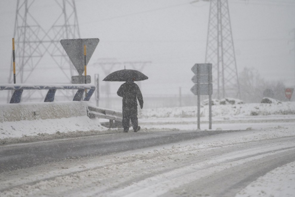 Un hombre camina, este sábado, sobre la nieve acumulada en la localidad cántabra de Reinosa en una jornada marcada por el frío y la inestabilidad.