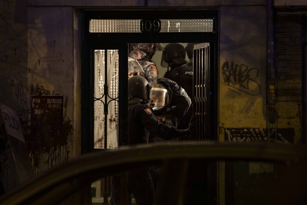 Un antidisturbios sale del portal de José Antonio y María José tras derribar la puerta para desahuciarlos en la calle Vía Carpetana de Madrid.
