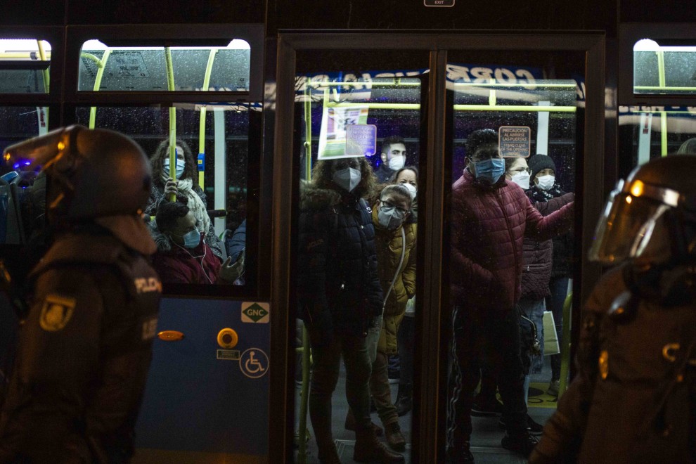 Usuarios del autobús urbano observan el despliegue policial para ejecutar el desalojo del matrimonio octogenario en Madrid.