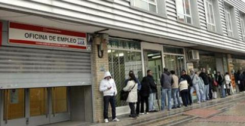 Un grupo de personas forman una fila frente a una oficina del INEM.