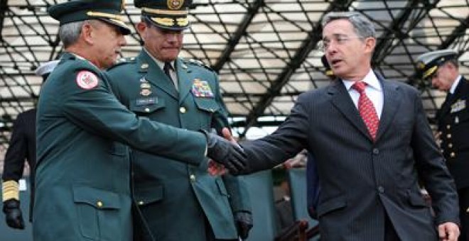 El entonces presidente colombiano, Álvaro Uribe, saluda al comandante del Ejército, general Óscar González, en una ceremonia en 2008. - AFP