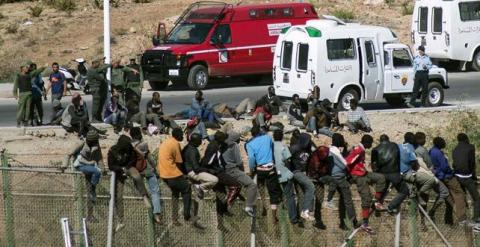 Inmigrantes subsaharianos encaramados en la valla de Melilla. REUTERS