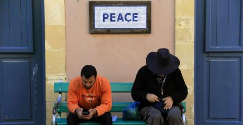 Un par de peatones sentados en un banco en la zona de seguridad administrada por la ONU en Nicosia, la única capital dividida del mundo, con el sur (griego) y el norte (turco) separada por la llamada 'Línea Verde' desmilitarizada. REUTERS / Yannis Behraki