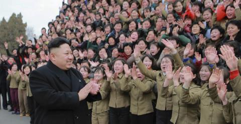 El líder de Corea del Norte Kim Jong Un junto a trabajadores de una planta textil. REUTERS/KCNA