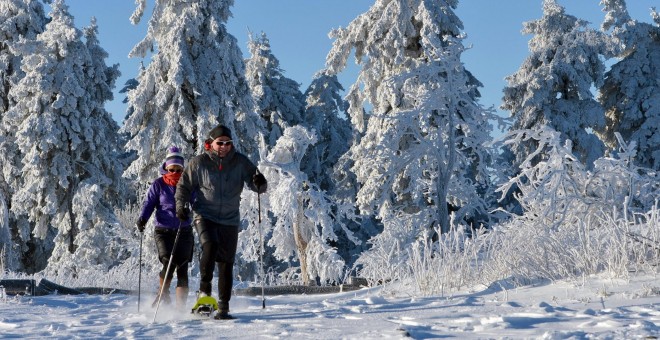 Dos personas caminan con raquetas de nieve en la montaña Grosser Feldberg, en la región de Taunus, en Schmitten (Alemania). EFE / EPA / ARNE Dedert