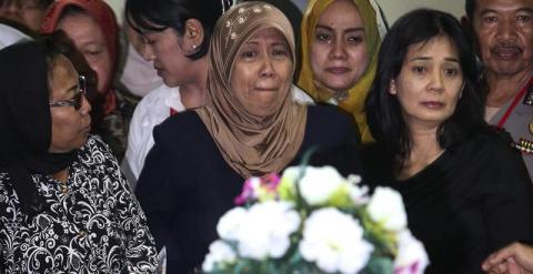 Varias familiares lloran junto al ataúd de Hayati Lutfiah, una de las víctimas del accidente del avión de AirAsia.- EFE