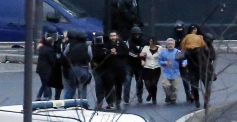 Agentes de Policía sacan a los rehenes de la tienda de París asaltada. /AFP