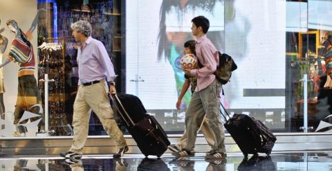 Pasajeros en la zona comercial de la terminal T1 de Barcelona. AENA