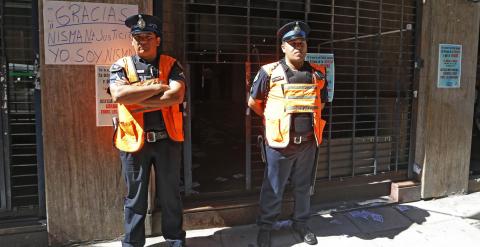 Dos policías argentinos custodian la entrada al domicilio de Nisman, por delante de un cartel colocado por un ciudadano en el que se lee 'Yo soy Nisman'. REUTERS