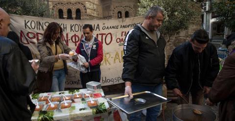 Miembros de una asociación reparten comida en la calle.